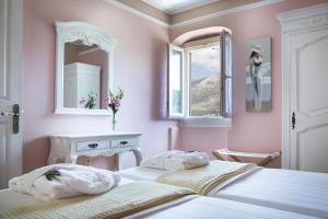 two beds in a pink bedroom with two mirrors at Iconic Villas - Villa Vada in Agia Effimia +31 photos