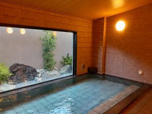 - une piscine avec un bassin à poissons dans une maison dans l'établissement Hotel Route-Inn Kameyama Inter, à Kameyama