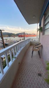 a balcony with a bench and a view of the water at Apartamento encantador em prédio histórico in Santos