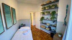 a bedroom with a bed and shelves with plants at Apartamento encantador em prédio histórico in Santos