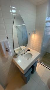 y baño con lavabo y espejo. en Apartamento encantador em prédio histórico en Santos