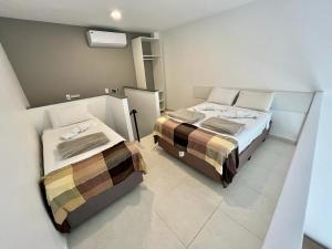 two beds in a small room with at Vila Capilano Ubatuba in Ubatuba