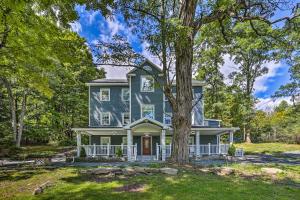 une maison bleue avec un arbre en face dans l'établissement Stunning South Fallsburg Home with Pool and Deck!, 
