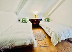 two beds sitting next to each other in a room at KANOLA Home in Sainte-Anne