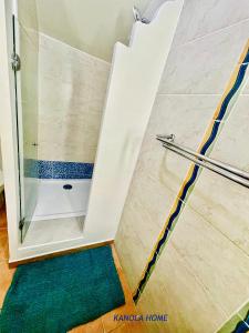 La salle de bains est pourvue d'une douche avec une porte en verre. dans l'établissement KANOLA Home, à Sainte-Anne