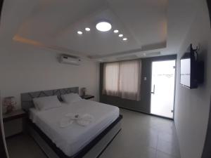 ein Schlafzimmer mit einem weißen Bett mit einer Blume darauf in der Unterkunft HOSTERIA PUERTO BALBANERA in Tonsupa