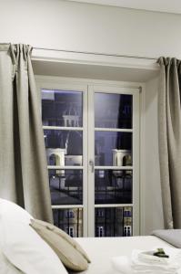a bedroom with a glass door with a window at Genova Porto Antico Boutique Rooms in Genoa