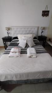 1 cama con 2 toallas y 2 almohadas en Vistalbahouse en Luján de Cuyo