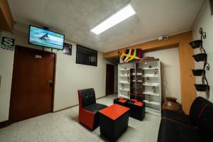 a waiting room with chairs and a tv and a door at HOSTAL TARAPACA in Huánuco