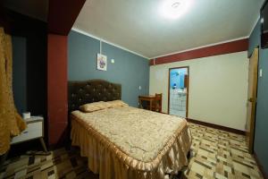 HOSTAL TARAPACA في هانوكو: غرفة نوم بسرير كبير في غرفة