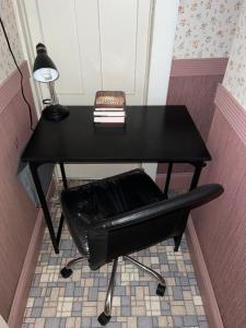 un escritorio negro con una silla negra y una lámpara en Pacifico's Place "A", en Hartford