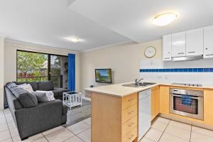 a kitchen and living room with a couch at North Facing, 2 bedroom Townhouse in Tropical Resort in Noosaville
