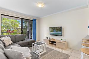 a living room with a couch and a table at North Facing, 2 bedroom Townhouse in Tropical Resort in Noosaville