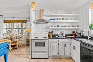 a kitchen with white cabinets and a stove top oven at Charming Cottage in Atlantic Beach