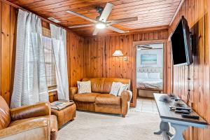 a living room with a couch and a ceiling fan at Charming Cottage in Atlantic Beach