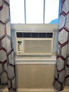 a window with a air conditioner in a room at Pacifico's Place "B" in Hartford
