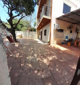 an empty driveway in front of a house with a tree at Hospedaje San Miguel in Luque