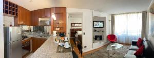 a kitchen with a refrigerator and a table with chairs at Brizen Apartments in Santiago