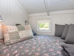 Schlafzimmer mit einem Bett und einem Fenster in der Unterkunft Holiday home Oksbøl LXXXIV in Oksbøl