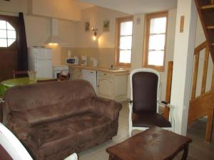 ein Wohnzimmer mit einem Sofa und einer Küche in der Unterkunft Gîte Dompierre-sur-Besbre, 3 pièces, 4 personnes - FR-1-489-174 in Dompierre-sur-Besbre