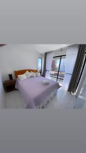 ein Schlafzimmer mit einem Bett und einem großen Fenster in der Unterkunft Departamento juan martines in Iquique