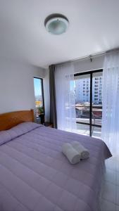 1 dormitorio con 1 cama grande y 2 almohadas en Departamento juan martines, en Iquique