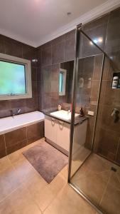 a bathroom with a shower and a sink and a tub at Woodbine Lodge in Marysville +5 photos