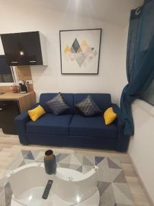 salon z niebieską kanapą z żółtymi poduszkami w obiekcie Studio agréable w mieście Manosque
