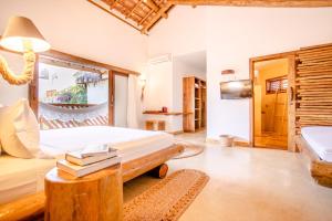 a bedroom with a bed and a table with books at VillaMag in Jericoacoara