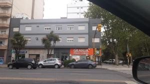 eine Straße mit Autos, die vor einem Gebäude geparkt sind in der Unterkunft Cala Hotel in Mar del Plata