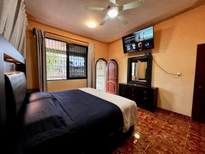 a bedroom with a bed and a flat screen tv at Family King size in Minatitlán