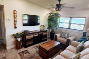 a living room with a tv and a couch and a table at Bali Bungalow - Downtown Cocoa Beach in Cocoa Beach