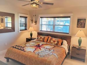 a bedroom with a bed and two lamps and a fan at Bali Bungalow - Downtown Cocoa Beach in Cocoa Beach