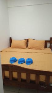 Una cama con dos almohadas azules encima. en Wellsuits Bangi, en Kajang