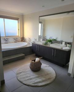 a bathroom with a tub and a sink and a mirror at Luxury Green in Greenvale