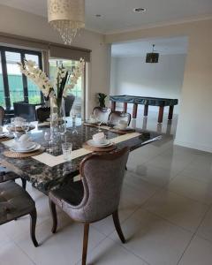 een eetkamer met een tafel met stoelen en een eetkamer bij Luxury Green in Greenvale