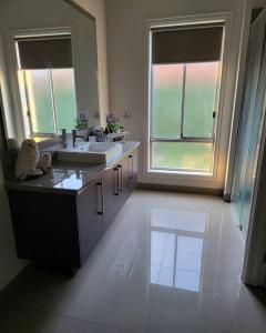 La salle de bains est pourvue de 2 lavabos et d'une grande fenêtre. dans l'établissement Luxury Green, à Greenvale