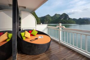 einen Balkon mit einem Tisch und Blick auf das Wasser in der Unterkunft Verdure Lotus Cruises in Hạ Long