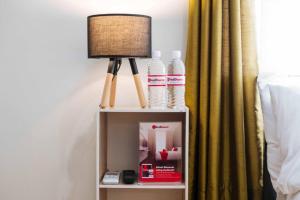a lamp on a night stand next to a bed at RedDoorz@EM Pensiontel Butuan City in Butuan