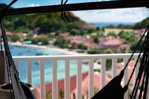 a hammock on a balcony with a view of a beach at Villa Rackam in Terre-de-Haut