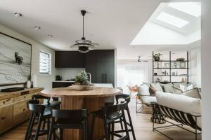 a kitchen and living room with a table and chairs at Dunes on Sandy Wha in Gerringong