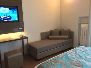 a living room with a couch and a flat screen tv at Hotel Ariston & Apartments in Varazze