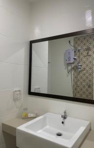 a bathroom with a white sink and a mirror at Wang Valley Resort in Pantai Cenang