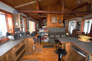 a large living room with wooden walls and wooden floors at Le petit Montebello in Grenville-sur-la-Rouge