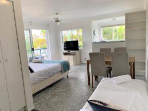 1 dormitorio con 2 camas, mesa y sillas en Broadwater Keys Holiday Apartments en Gold Coast