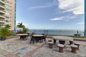 a patio with tables and chairs and the ocean at VIP Exclusive One Bedroom Apartment in Santo Domingo