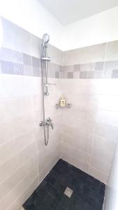 a bathroom with a shower with a black tile floor at Le Marie-Agnès Appartement neuf de Standing in Fort-de-France