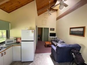 a kitchen and living room with a refrigerator and a couch at Kosciuszko Base Camp in Khancoban