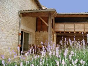 a garden with purple flowers in front of a building at Gîte avec Piscine Chauffée, Jacuzzi et Jardin Privé - FR-1-653-156 in Charras