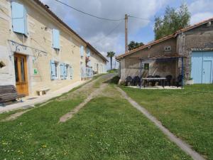 un camino de tierra entre dos edificios con mesa y sillas en Gîte Chalais, 5 pièces, 8 personnes - FR-1-653-170, en Chalais